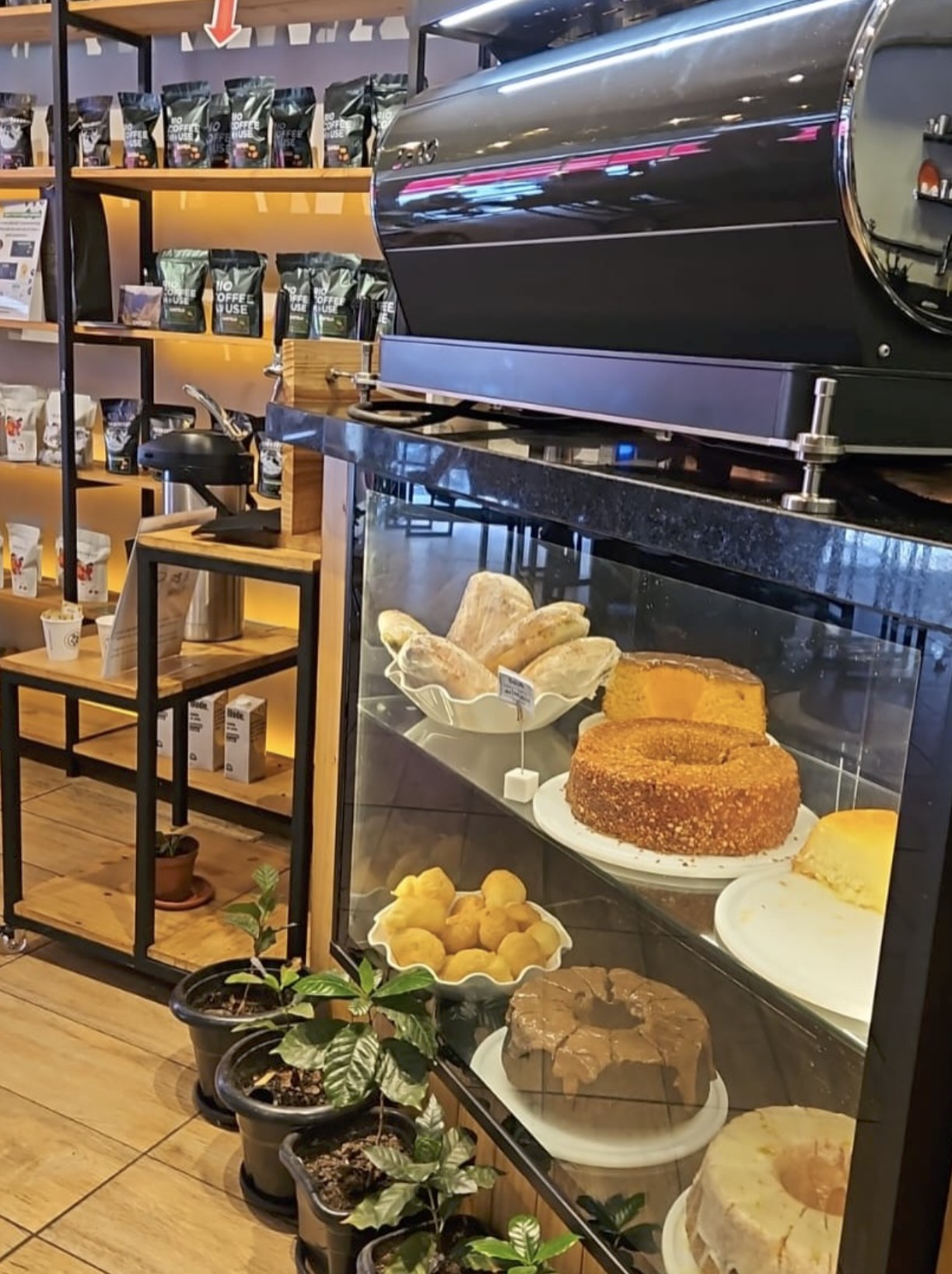 Retail shelving, the roaster and a pastry case inside Rio Coffee House